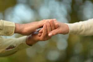 elderly people holding hands