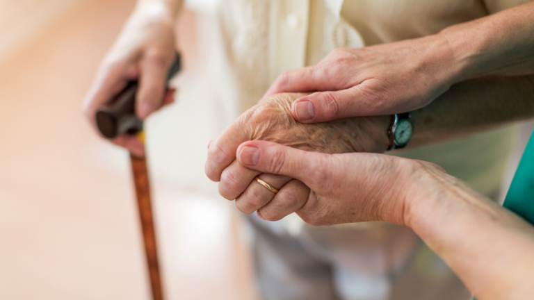 Elder holding hands with caregiver