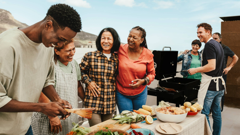 Blended family smiling while barbecuing and prepping a lovely meal.