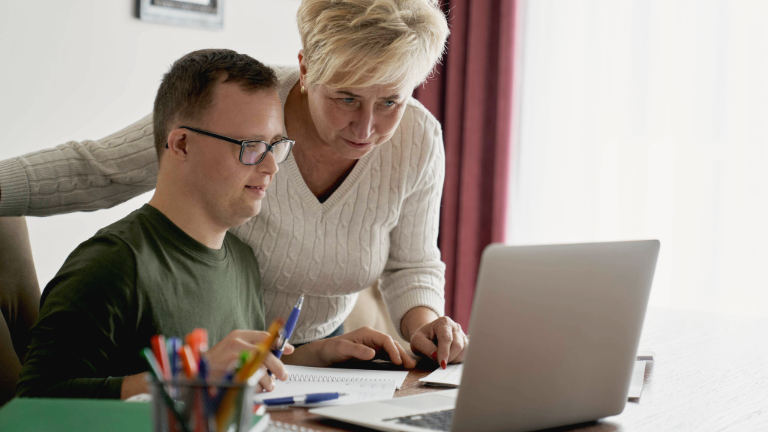 Person with disabilities being helped on the computer